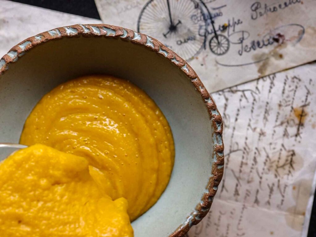 pouring squash soup into bowl